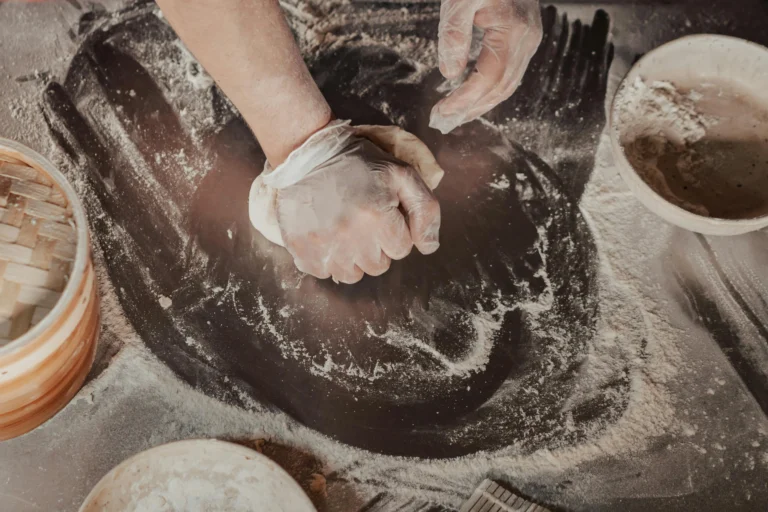 A person cooking while wearing kitchen hand glove