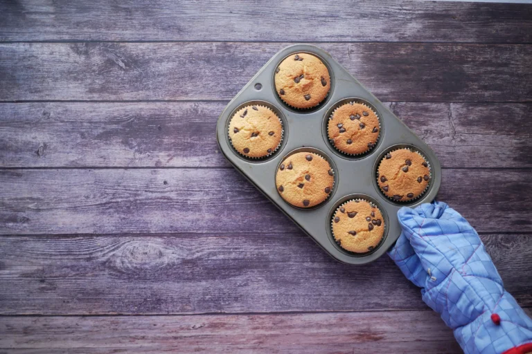 Holding freshly baked cupcakes with a potholder